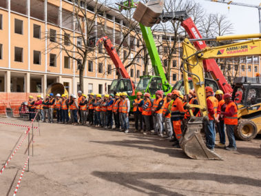 operai schierati con escavatori